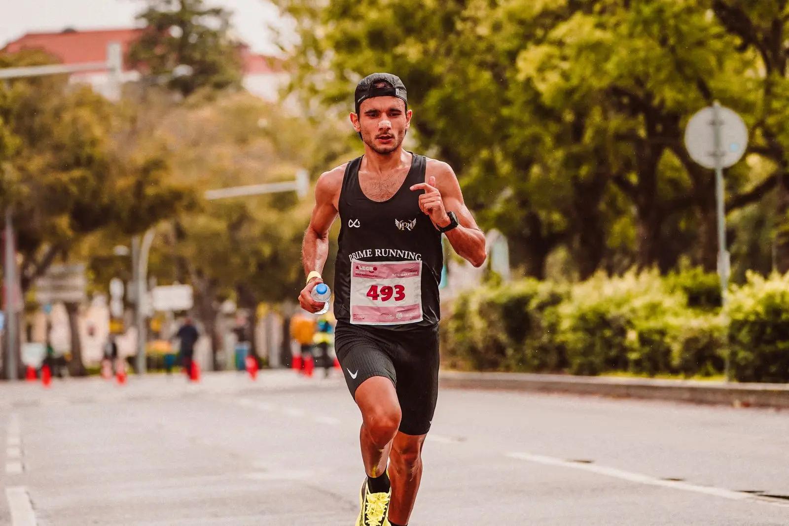 A runner in a road race, holding a bottle of water