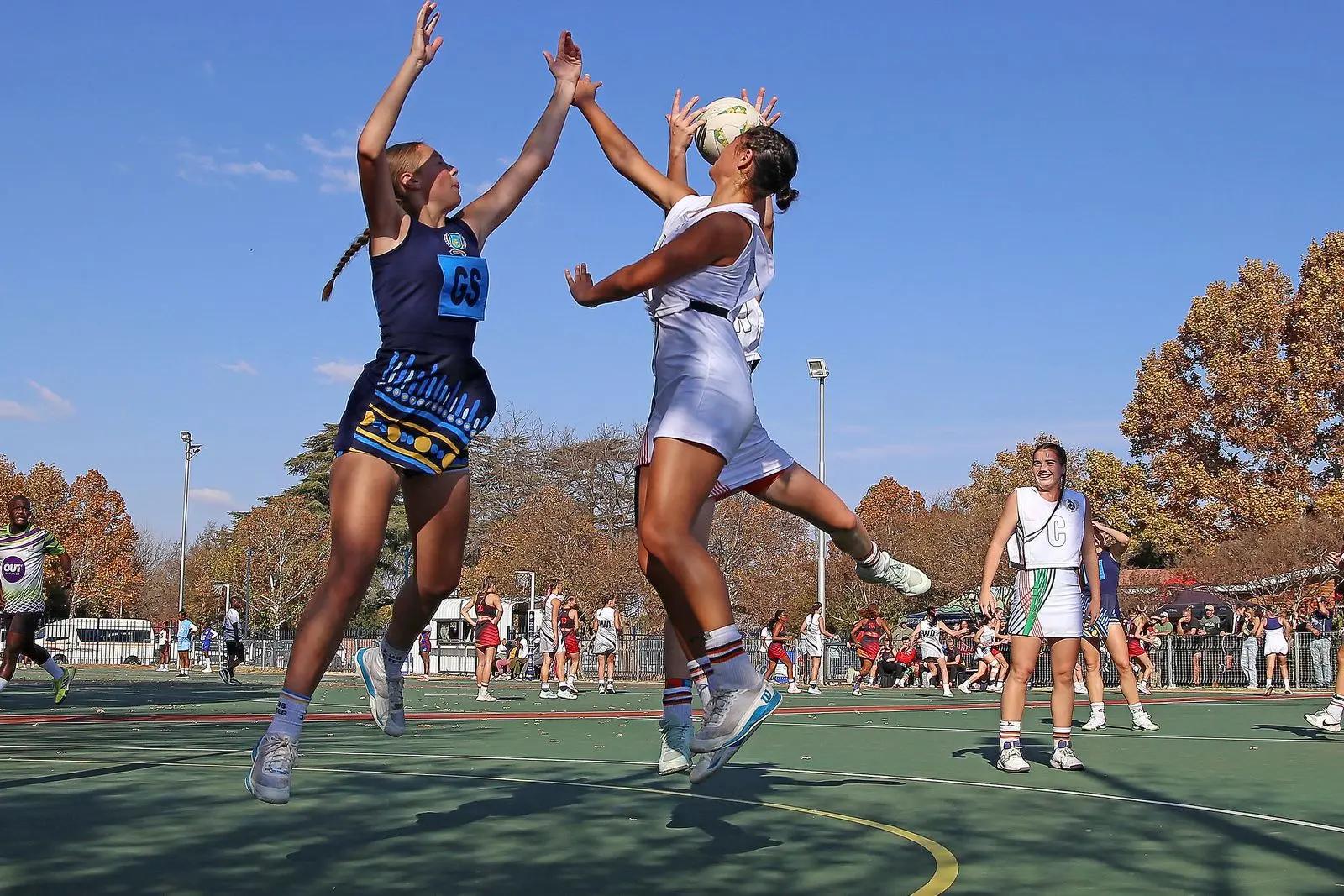Two netball players jumping for the ball